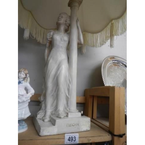 493 - A tall plaster figural table lamp with shade.