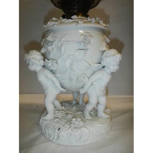 528 - A superb quality white glazed porcelain oil lamp surmounted with cherubs and with drop in font, COLL... 