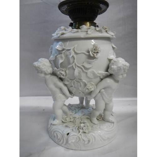 528 - A superb quality white glazed porcelain oil lamp surmounted with cherubs and with drop in font, COLL... 