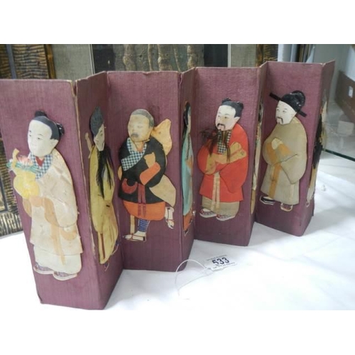 533 - A miniature Chinese seven paneled screen with embossed fabric figures.