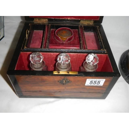 555 - A Victorian mahogany ladies travelling box with three scent bottles.