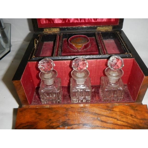 555 - A Victorian mahogany ladies travelling box with three scent bottles.