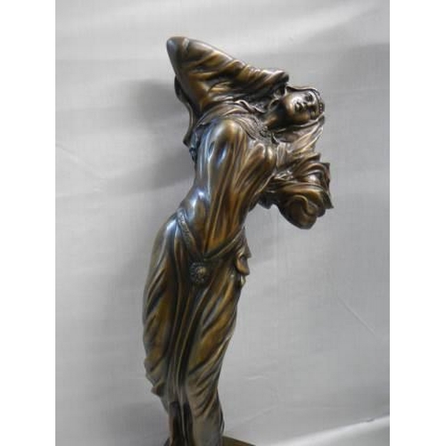 558 - A tall bronze figure of a female.