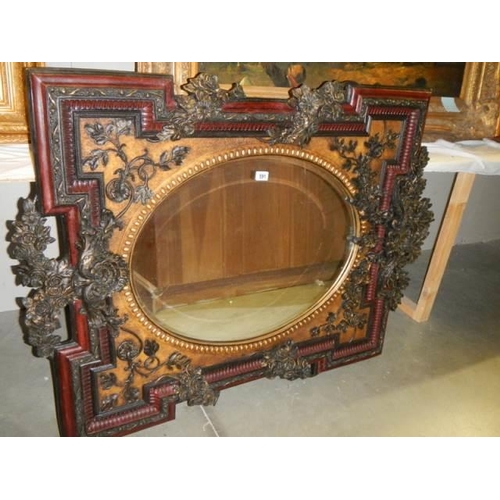 591 - A large oval decorative framed mirror. COLLECT ONLY.