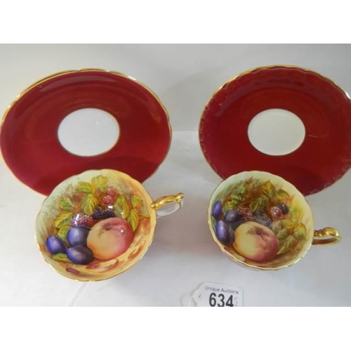 634 - Two Aynsley Orchard Gold teacups and saucers signed D Jones.