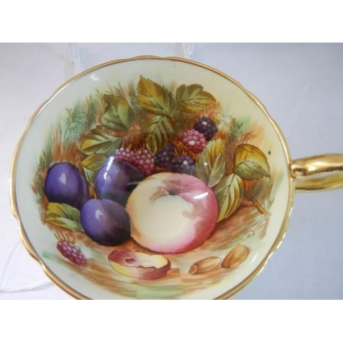 644 - An Aynsley Orchard Gold Apricot cup and saucer with gold footing signed D Jones.