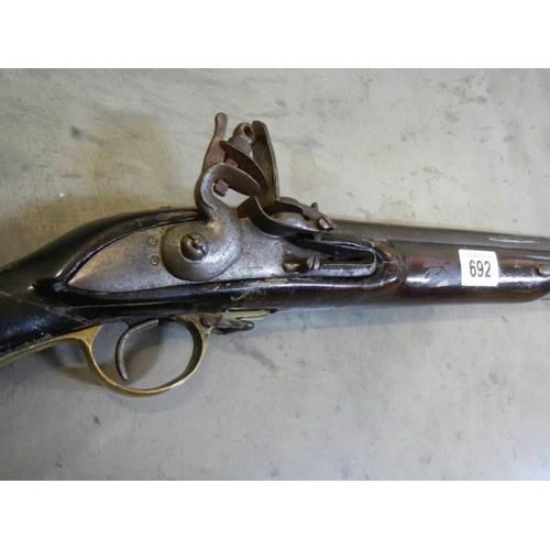 692 - A early Brown Bess musket, complete including hammer mechanism but all woodwork needs serious repair... 