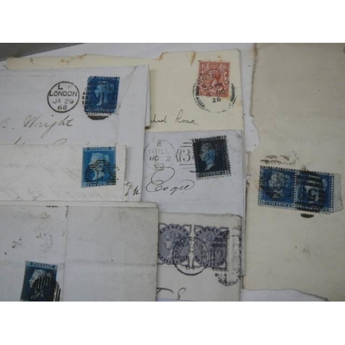 712 - A collection of 19th century stamps on envelopes including two penny blues.