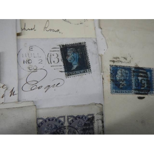 712 - A collection of 19th century stamps on envelopes including two penny blues.