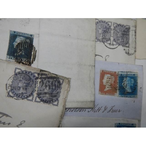 712 - A collection of 19th century stamps on envelopes including two penny blues.