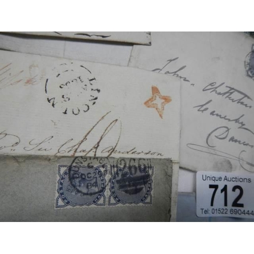 712 - A collection of 19th century stamps on envelopes including two penny blues.