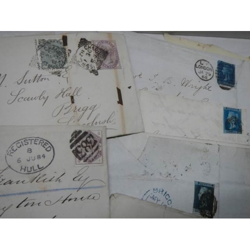 712 - A collection of 19th century stamps on envelopes including two penny blues.