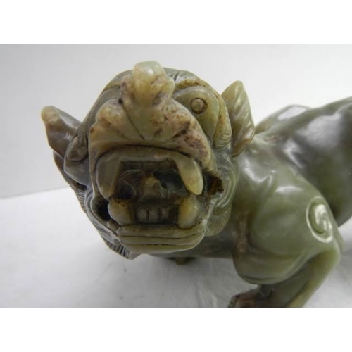 844 - A powerful Chinese jade figure of a mythical lion. H 13cm x  W 20cm.