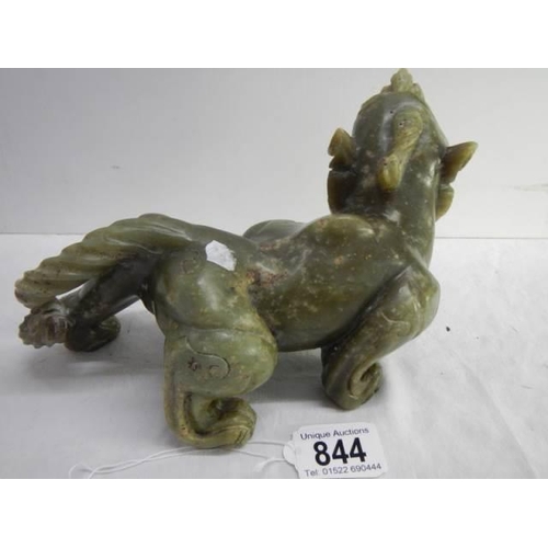 844 - A powerful Chinese jade figure of a mythical lion. H 13cm x  W 20cm.