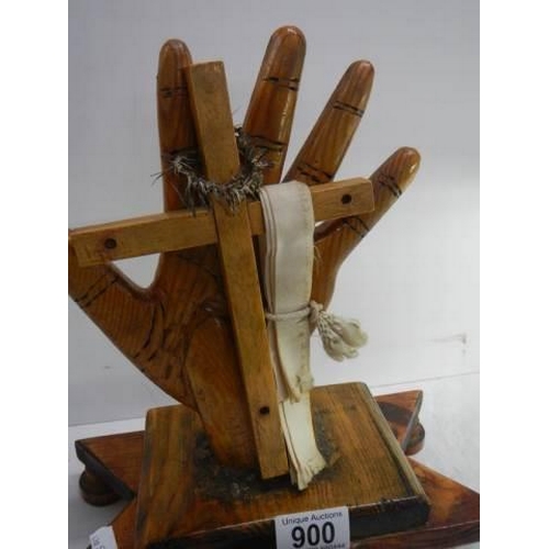 900 - A wooden hand supported a cross.