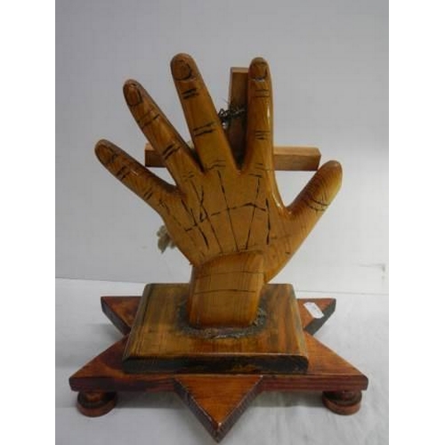 900 - A wooden hand supported a cross.