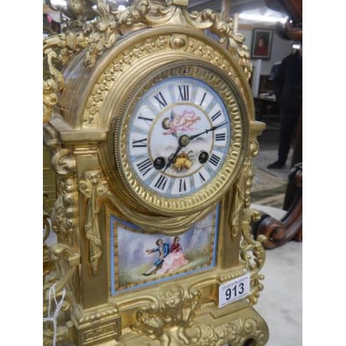 913 - A French ormolu mantel clock with enamel dial and porcelain panel.