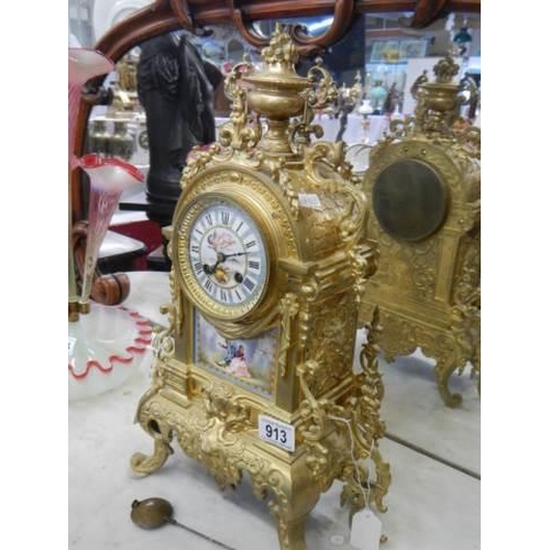 913 - A French ormolu mantel clock with enamel dial and porcelain panel.