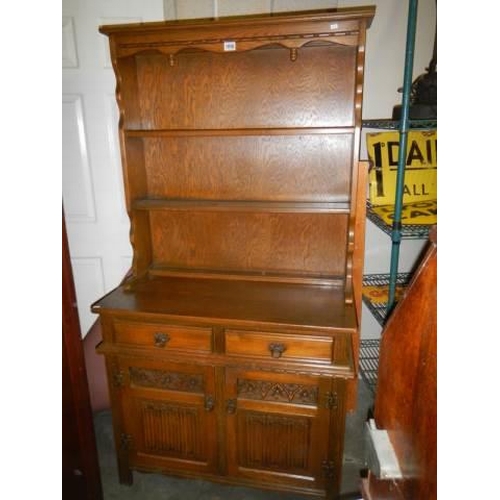 1056 - An open rack oak dresser with two cupboards and two drawers, COLLECT ONLY.