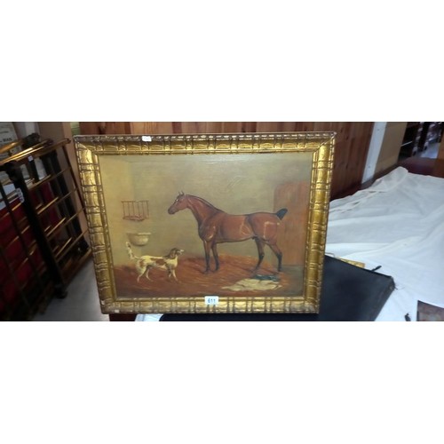 611 - A gilt framed painting of a horse and dog in a stable.