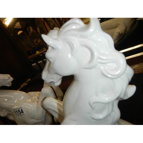 1154 - A pair of white ceramic rearing horses (one ear a/f)