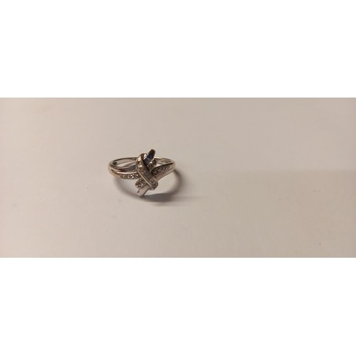 144 - A diamond ring fashioned as a crossover in 9ct white gold, size K half, 2.2 grams.