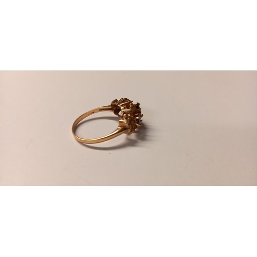 150B - A three stone ring set with oval garnets in a textured mount gold shank, size P, 2.8 grams.