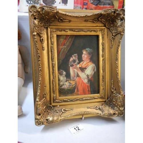12 - A gilt framed study of a lady with cat and kittens.