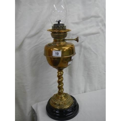 19 - A brass oil lamp on a pot base and complete with chimney.