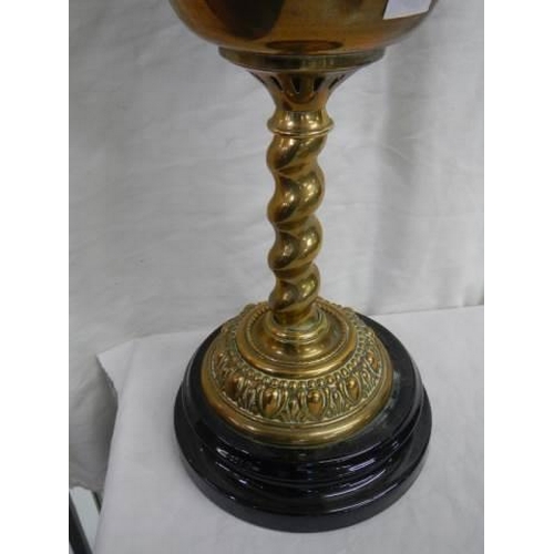 19 - A brass oil lamp on a pot base and complete with chimney.