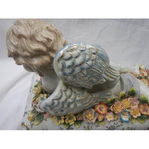 218 - A porcelain trinket pot with cherub on lid.