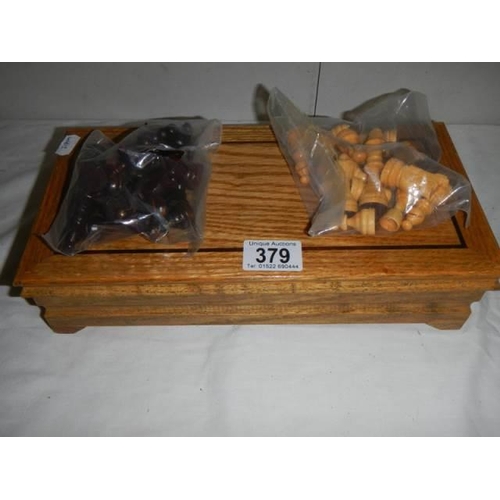 379 - A cased chess set in wooden box with swivel top board.