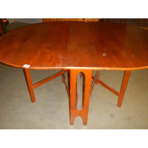 598 - An oval teak drop leaf table, COLLECT ONLY.