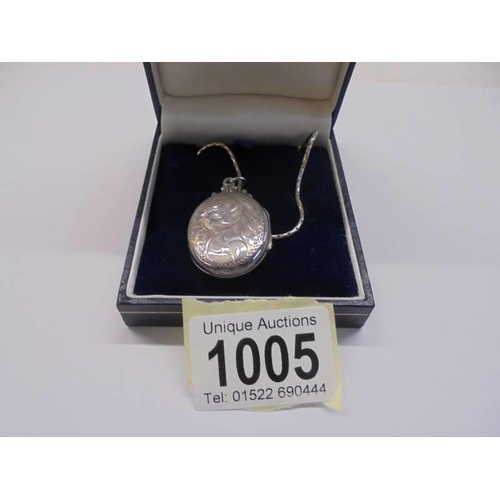 1005 - A silver locket on a silver chain,