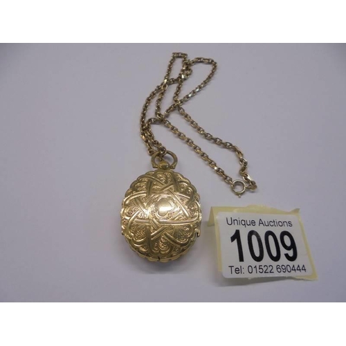 1009 - An unusual double sided yellow metal locket with domed glass on a 13.25 gramm 9ct gold chain.