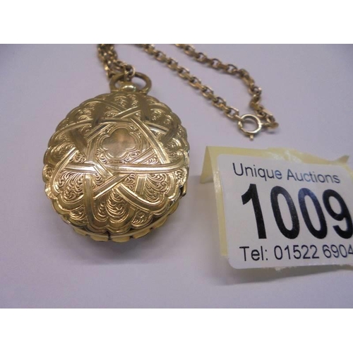 1009 - An unusual double sided yellow metal locket with domed glass on a 13.25 gramm 9ct gold chain.