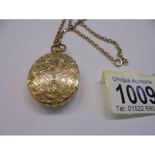 1009 - An unusual double sided yellow metal locket with domed glass on a 13.25 gramm 9ct gold chain.