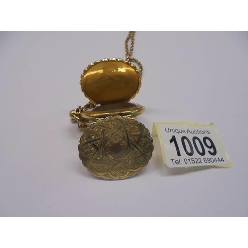 1009 - An unusual double sided yellow metal locket with domed glass on a 13.25 gramm 9ct gold chain.