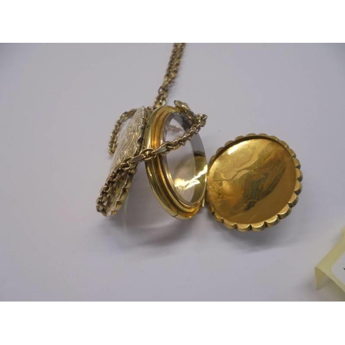 1009 - An unusual double sided yellow metal locket with domed glass on a 13.25 gramm 9ct gold chain.