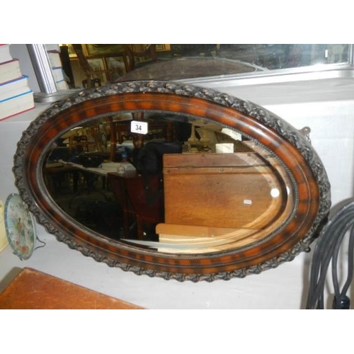 34 - An oval framed bevel edged mirror, COLLECT ONLY.