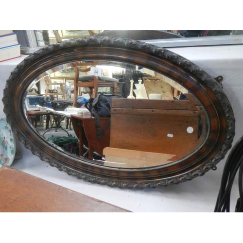 34 - An oval framed bevel edged mirror, COLLECT ONLY.