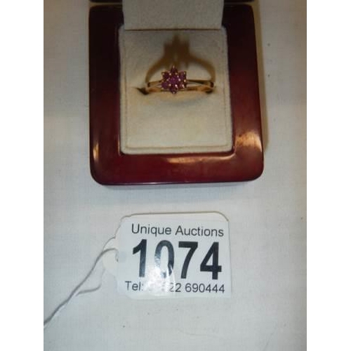 1074 - A ruby stone set ring in a cluster design, hall marked London 1965