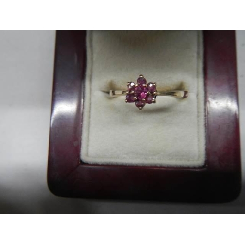 1074 - A ruby stone set ring in a cluster design, hall marked London 1965