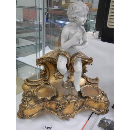 1492 - A cherub figure on a gilt stand.