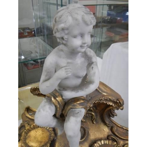 1492 - A cherub figure on a gilt stand.