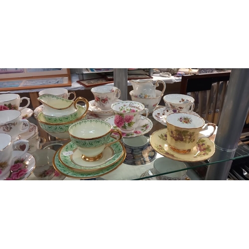 144 - A good selection of china cups and saucers plus trios, including Royal Albert etc