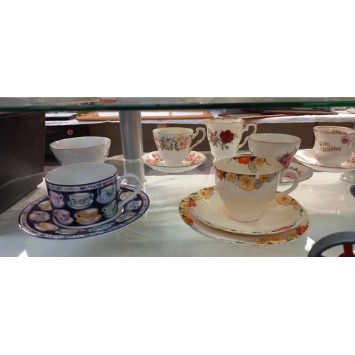 144 - A good selection of china cups and saucers plus trios, including Royal Albert etc