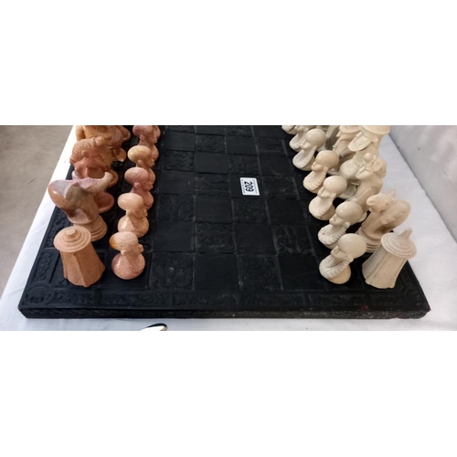 209 - A polished stone African chess set on a chess board (2 pieces a/f, some smaller ones have nibbles)