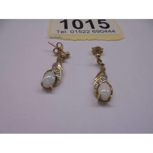 1015 - A pair of yellow gold and opal earrings, 1.65 grams.