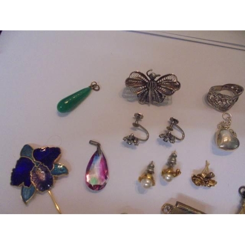 1033 - A mixed lot of earrings and charms including a silver butterfly.